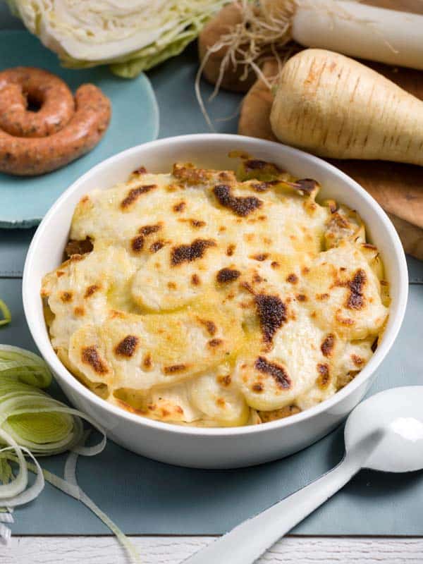 Gratin de chipolata, légumes d’hiver, pommes de terre et sauce au fromage